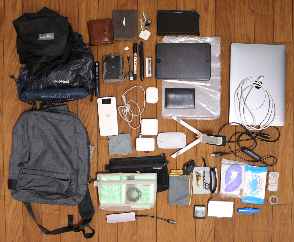 A minimalist desk with a single compact GaN charger on the floor and one cable running up to the laptop