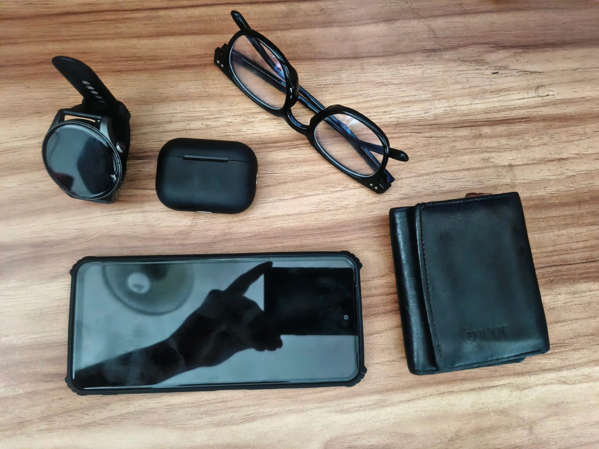 A pair of wireless earbuds and their open charging case resting on a white gym towel next to a water bottle
