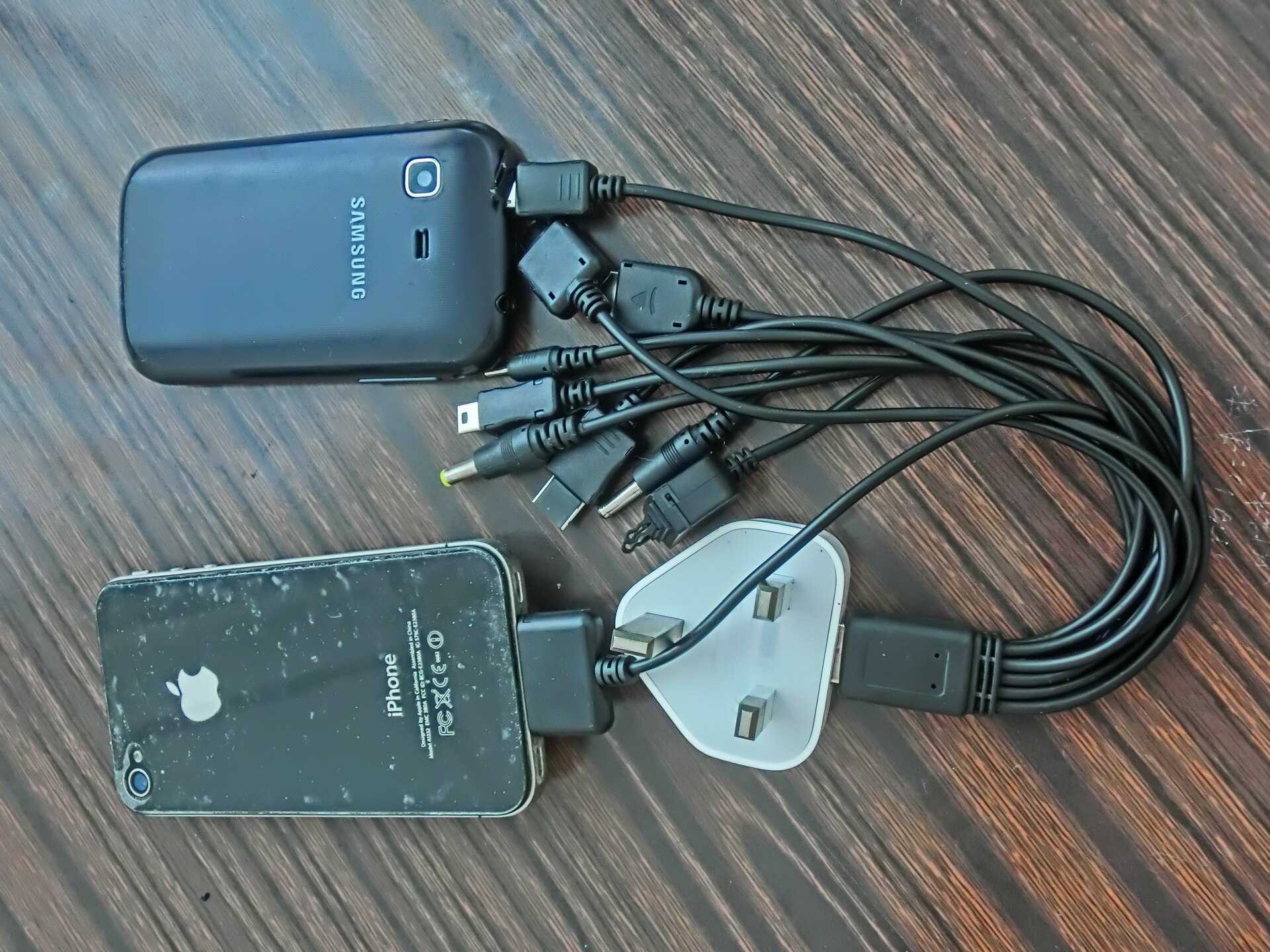 A traveler charging a phone at an airport gate while waiting for a delayed evening flight